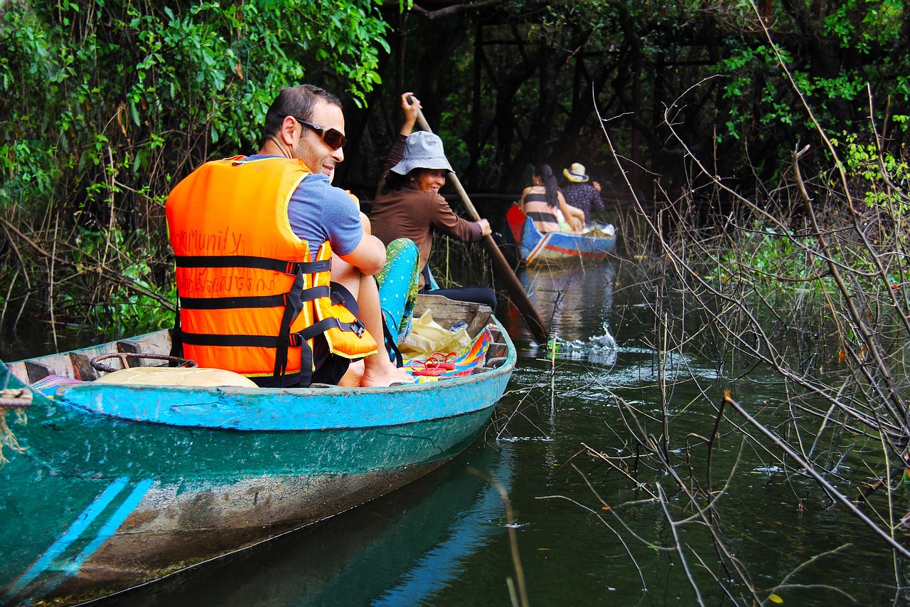 Tourists boating into the flooded forest of Tonle Sap Lake, surrounded by tranquil waters in Cambodia