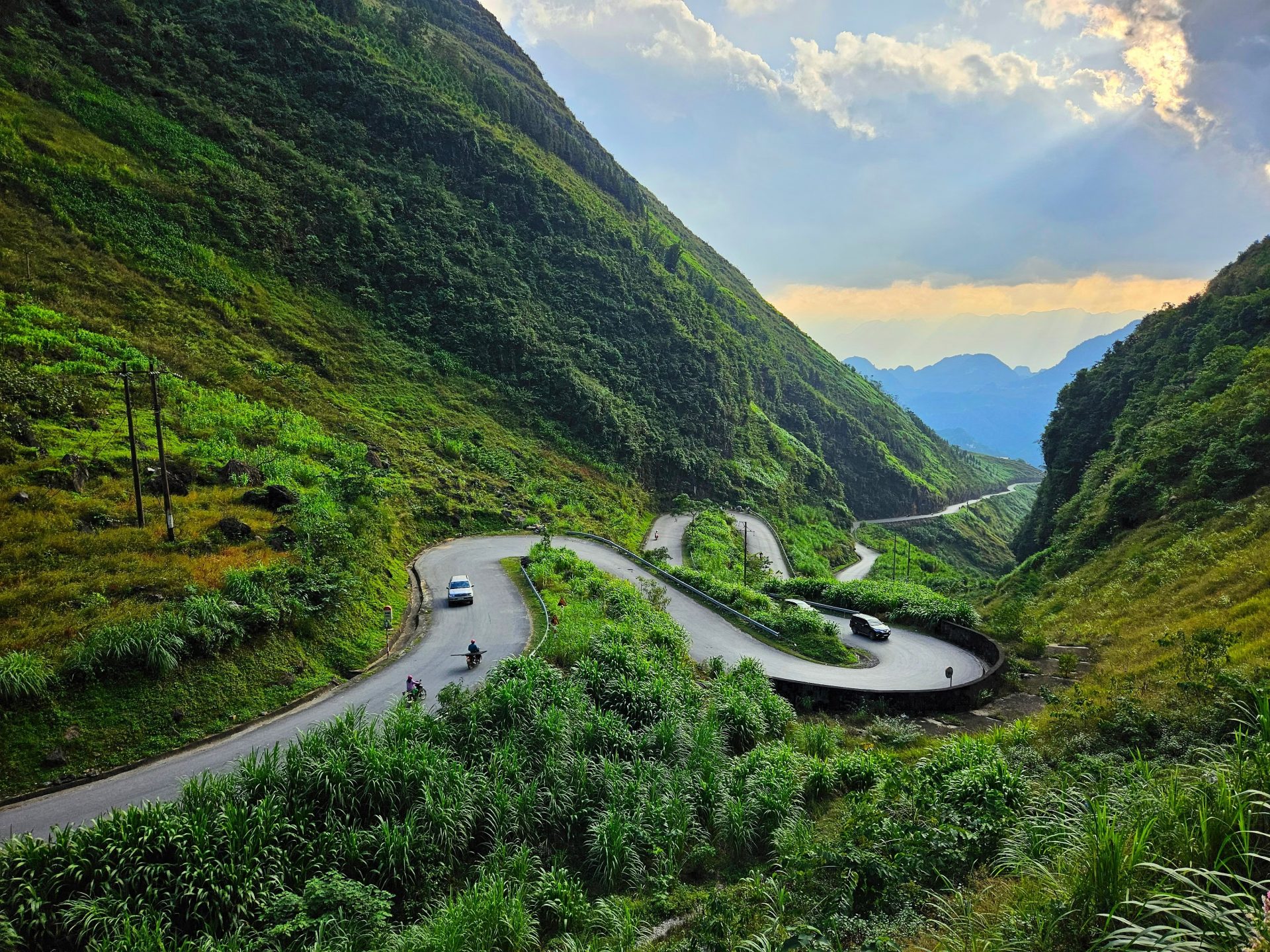 Adventure photographer on Ha Giang Loop, winding through northern Vietnam's towering limestone peaks.