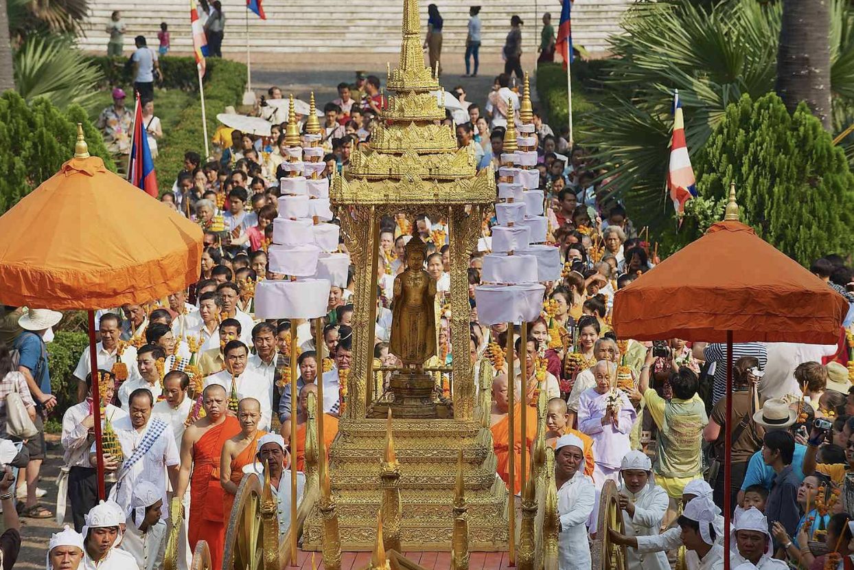 Lao New Year procession in Luang Prabang with monks and locals — a vibrant tradition during spiritual travel in Laos.