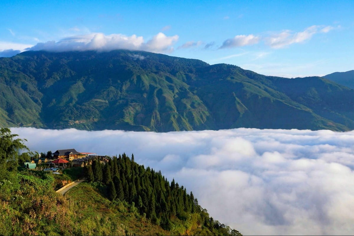 Mountain peaks above a sea of clouds in northern Vietnam, viewed from a highland village.