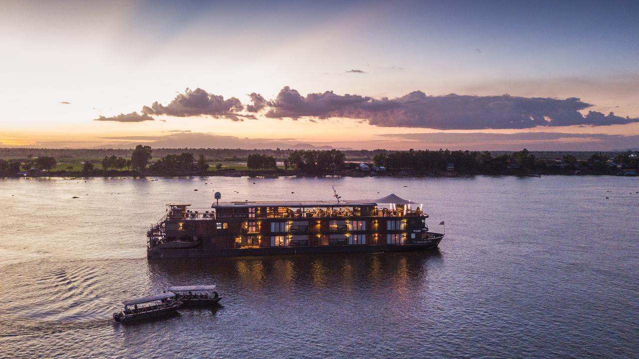 Cruising on Tonle Sap Lake, with boats passing floating villages and lush waters in Cambodia.
