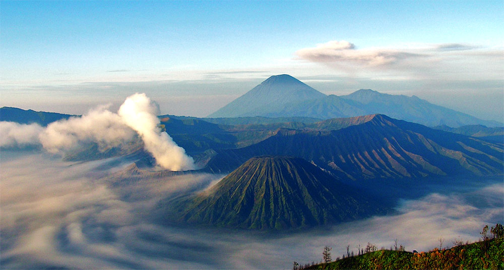 FIT travel Southeast Asia at Mount Bromo - Sunrise over Java’s volcanic landscape with steaming craters and the towering Semeru peak