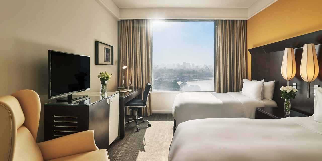 Twin bedroom with wide city view window at hotel pan pacific hanoi