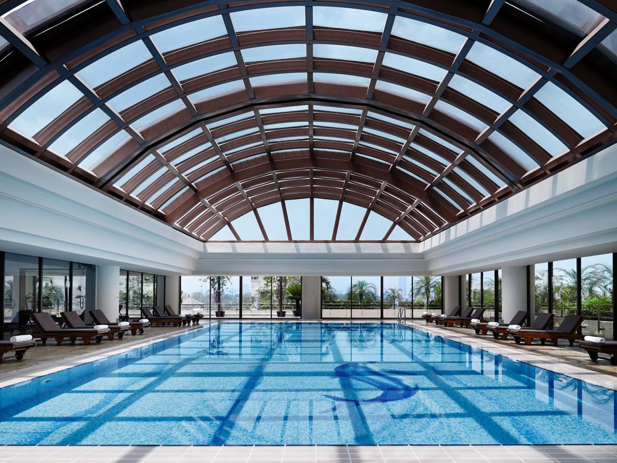 Indoor swimming pool with modern glass dome at hotel pan pacific hanoi