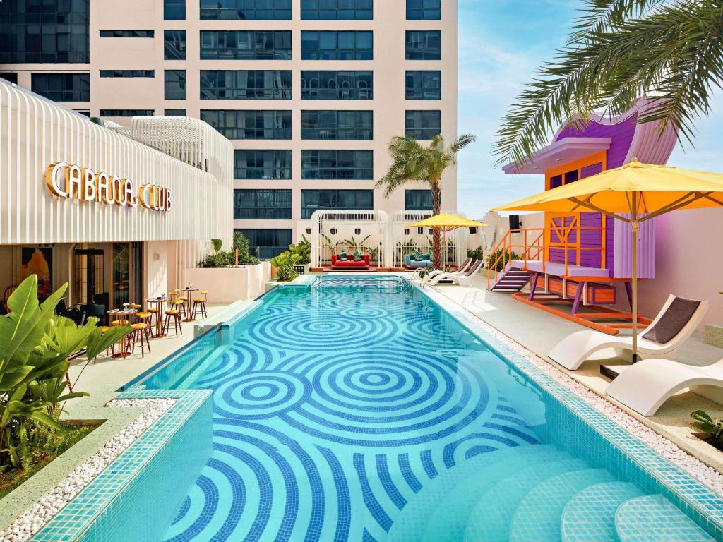 Outdoor swimming pool with Cabana Club and modern facilities at mövenpick hotel hanoi