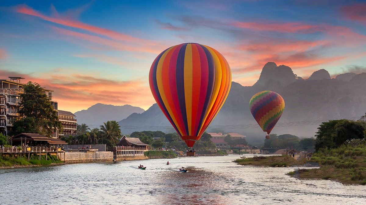 Tailor-made tours for agencies must provide unique and local experiences like Nam Song river at sunset with hot air balloon in Vang Vieng, Laos, Beautifull landscape on the Nam Song River in Vang Vieng, Laos.