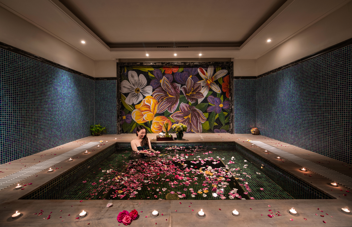 Aromatherapy flower bath at Ninh Binh Hidden Charm Hotel & Resort offering a serene wellness experience with artistic floral mosaic wall.