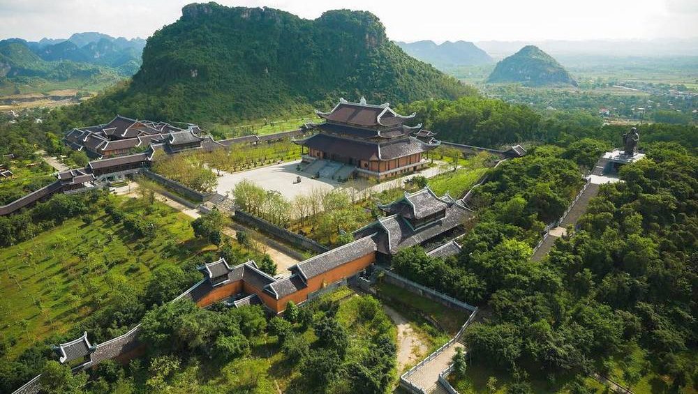 Aerial view of Bai Dinh Pagoda near lalita boutique hotel, featuring traditional temples, mountain backdrop, and peaceful rural landscape.