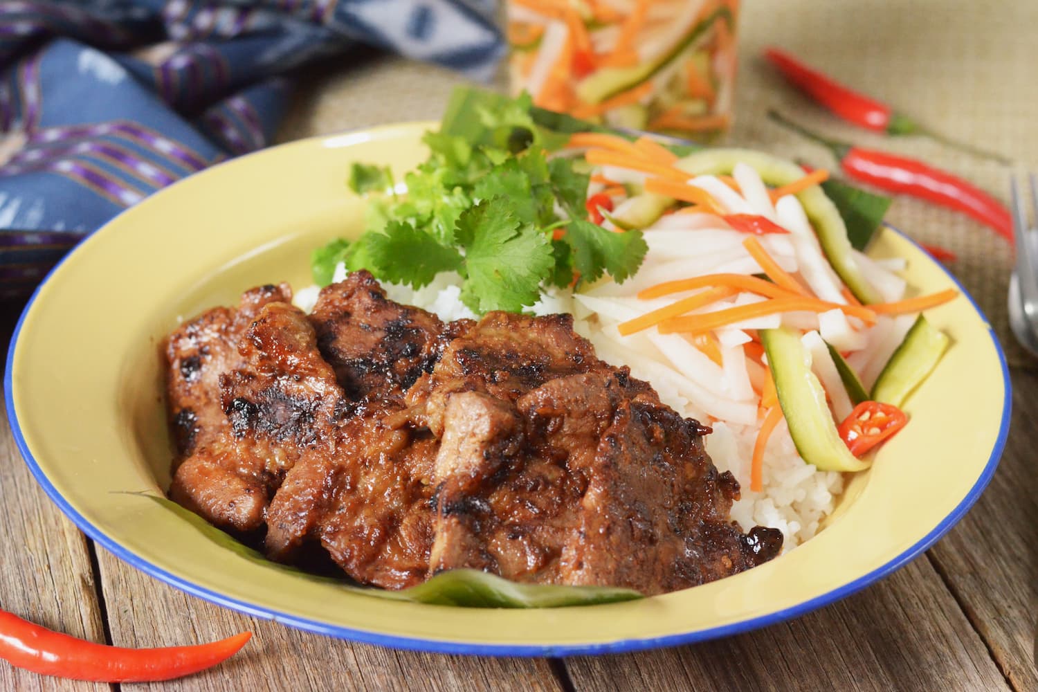 A plate of Bai Sach Chrouk, grilled pork and rice, a popular Cambodian cuisine breakfast dish