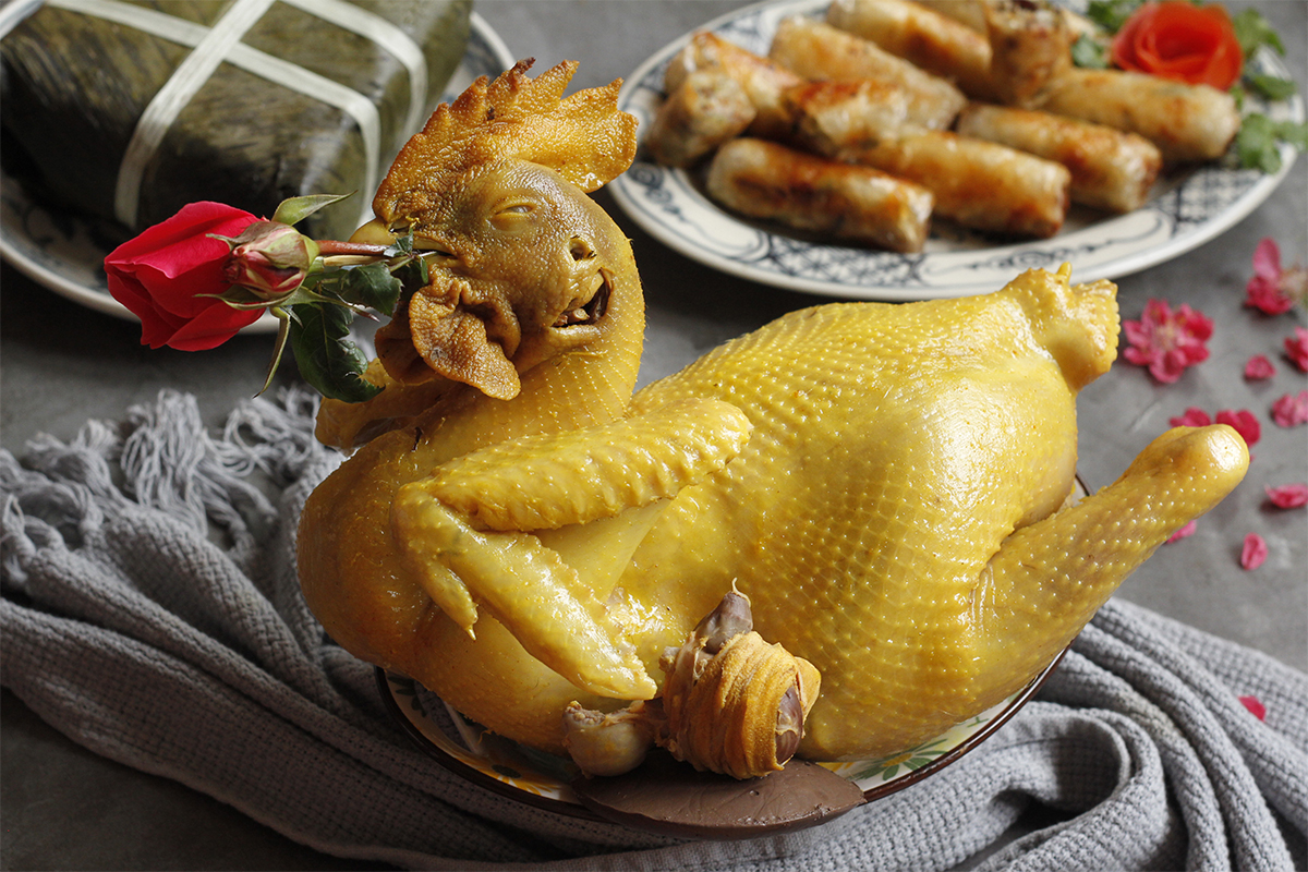 Boiled chicken served with rose and Bánh Chưng, a symbolic Vietnamese New Year’s Food representing prosperity and family reunion during Tết.