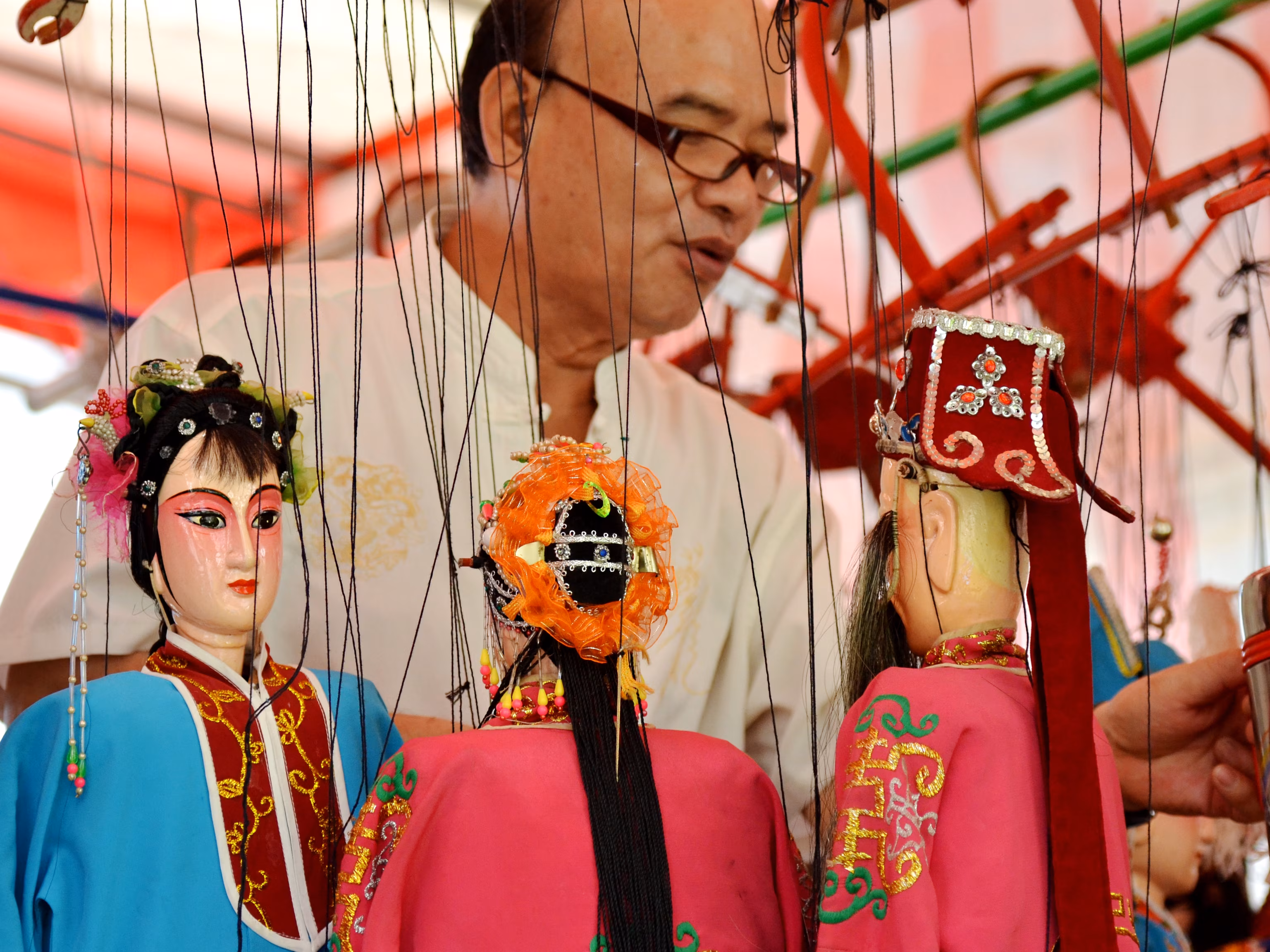 A performer manipulates a detailed traditional Chinese hand puppet, showcasing the vibrant artistic heritage found in Southeast Asia culture