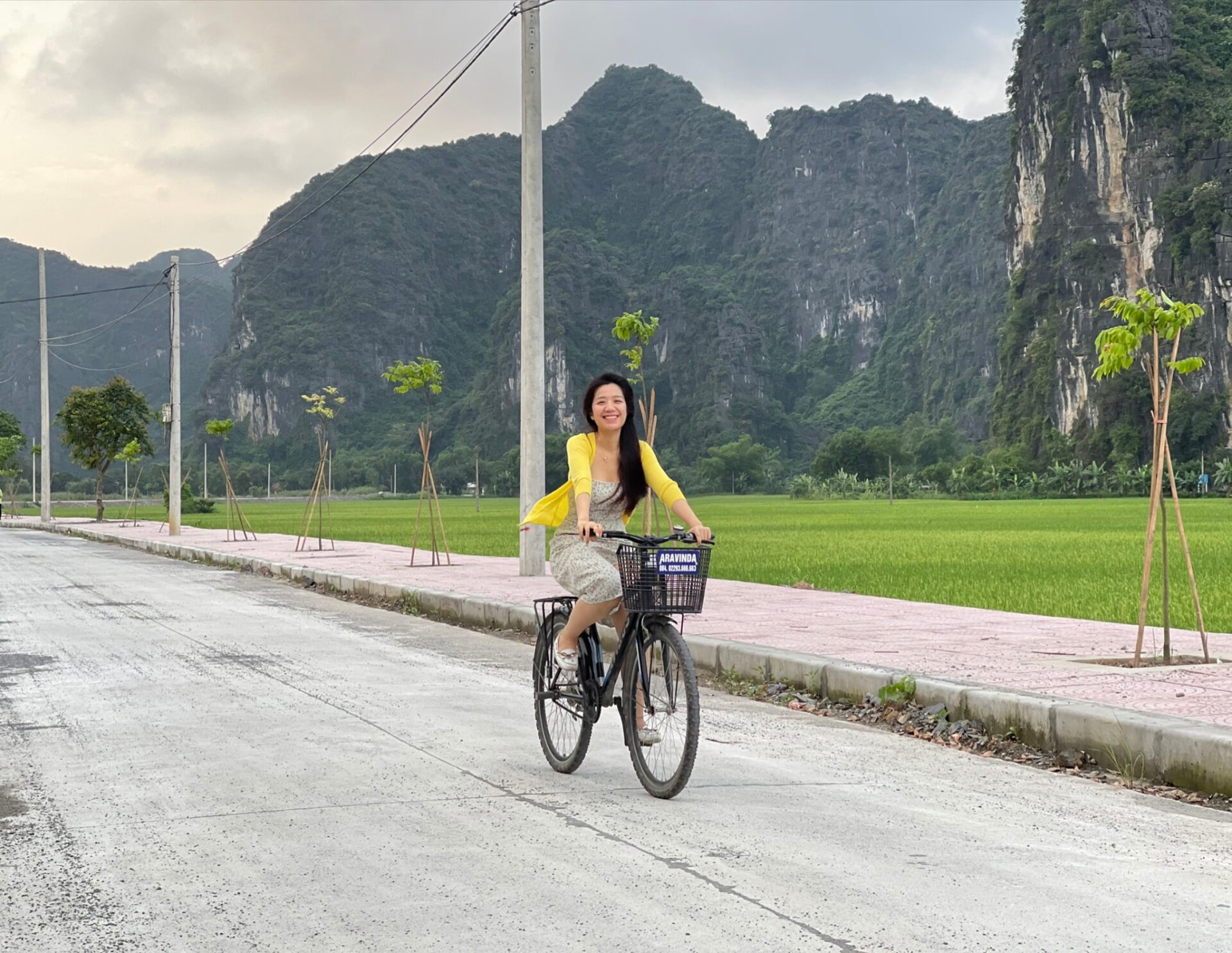 Visitors at Aravinda Resort Ninh Binh enjoy cycling through lush rice fields, surrounded by majestic limestone mountains and peaceful countryside.