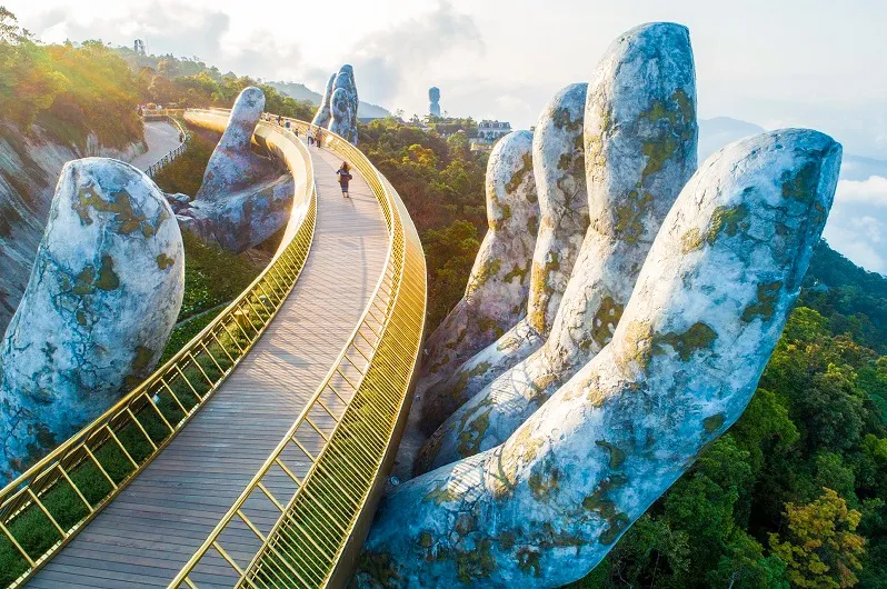 Giant, moss-covered hands holding the Golden Bridge pedestrian walkway 