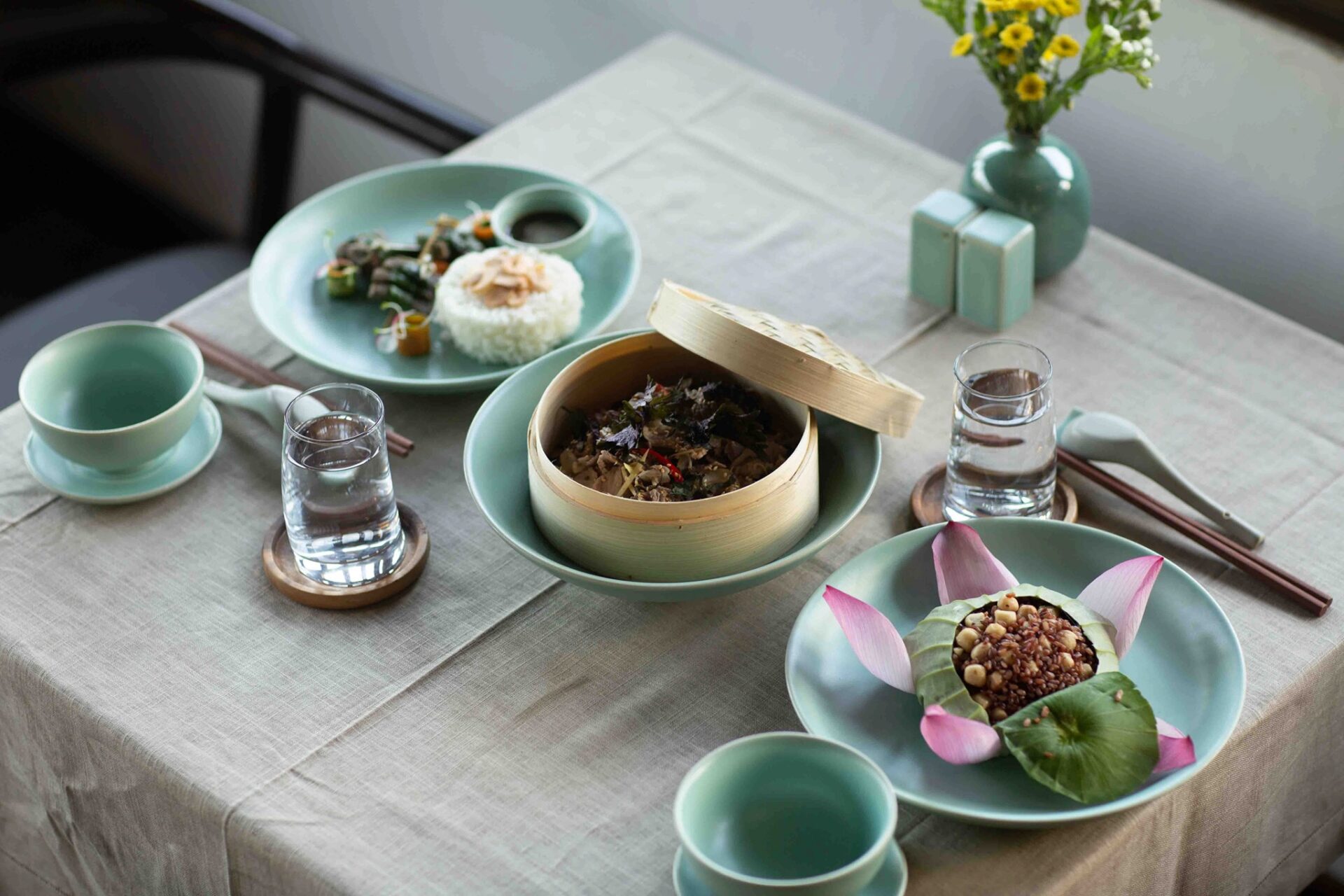 Healthy Vietnamese cuisine at Aravinda Resort Ninh Binh, featuring rice, lotus-wrapped dishes, fresh vegetables, and elegant farm-to-table dining presentation.