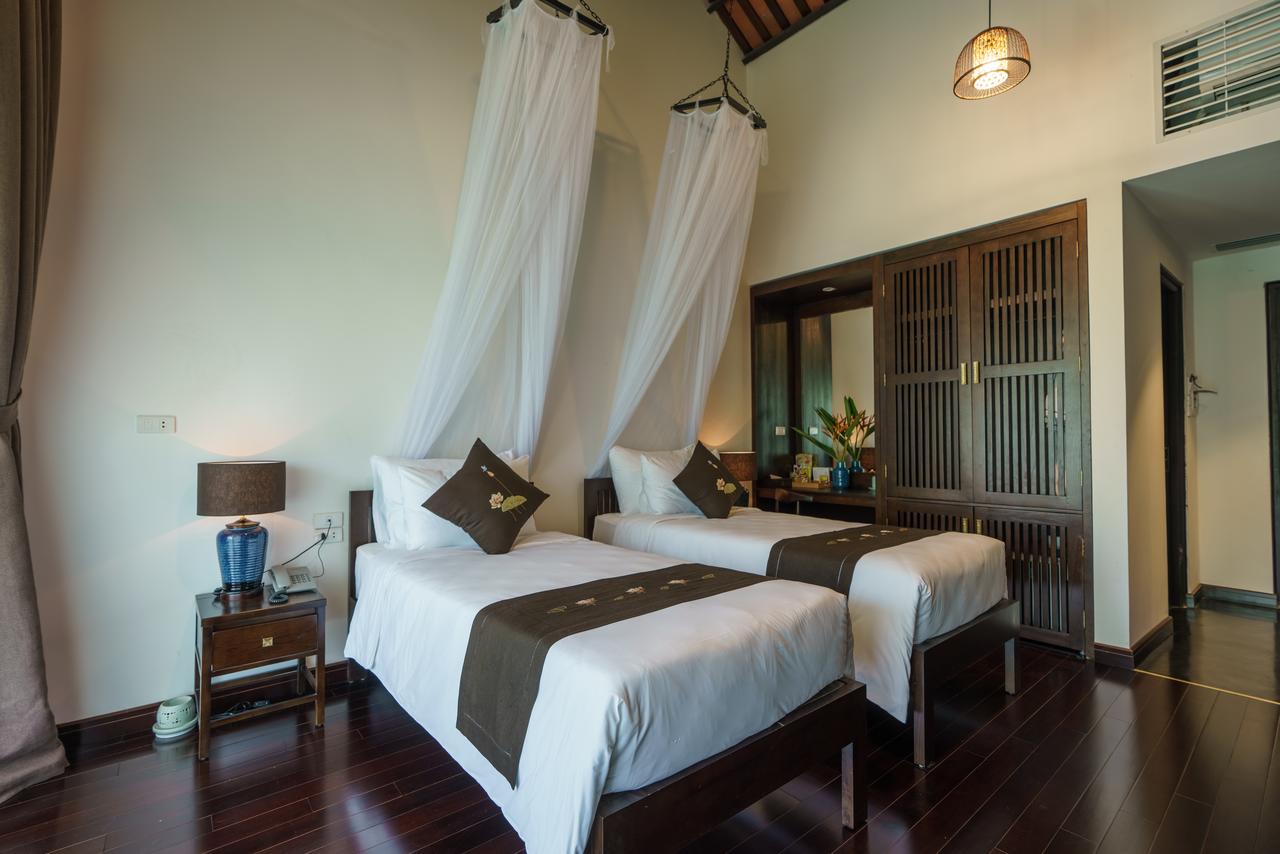 Twin-bed setup in Valleyfield Executive at Aravinda Resort Ninh Binh, featuring elegant wooden design, modern amenities, and serene ambiance.