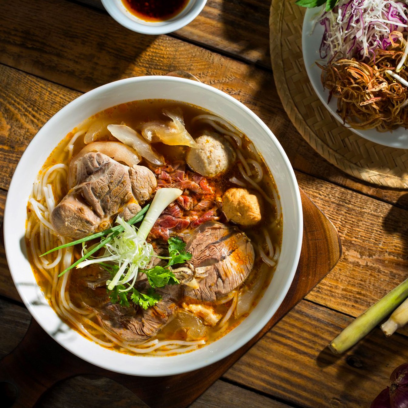 A hearty bowl of bun bo hue, a spicy beef noodle soup that represents the bold flavors of authentic Vietnam street food.