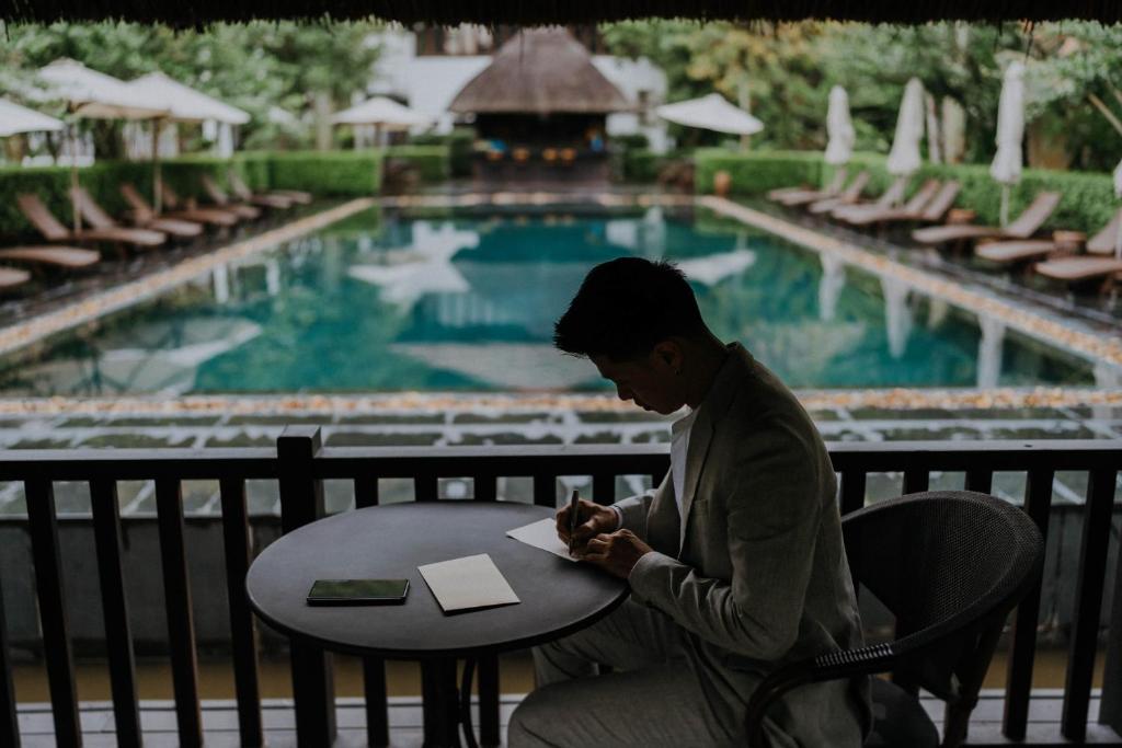 Cozy reading corner at Aravinda Resort Ninh Binh with rattan chairs, soft lighting, bookshelves, and elegant decor for relaxation.