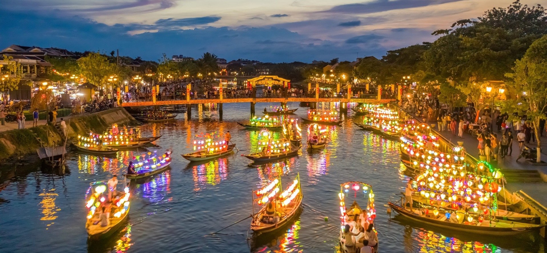 Hoi An Ancient Town, Vietnam in March – colorful lanterns reflecting on Thu Bon River during the warm spring evening.