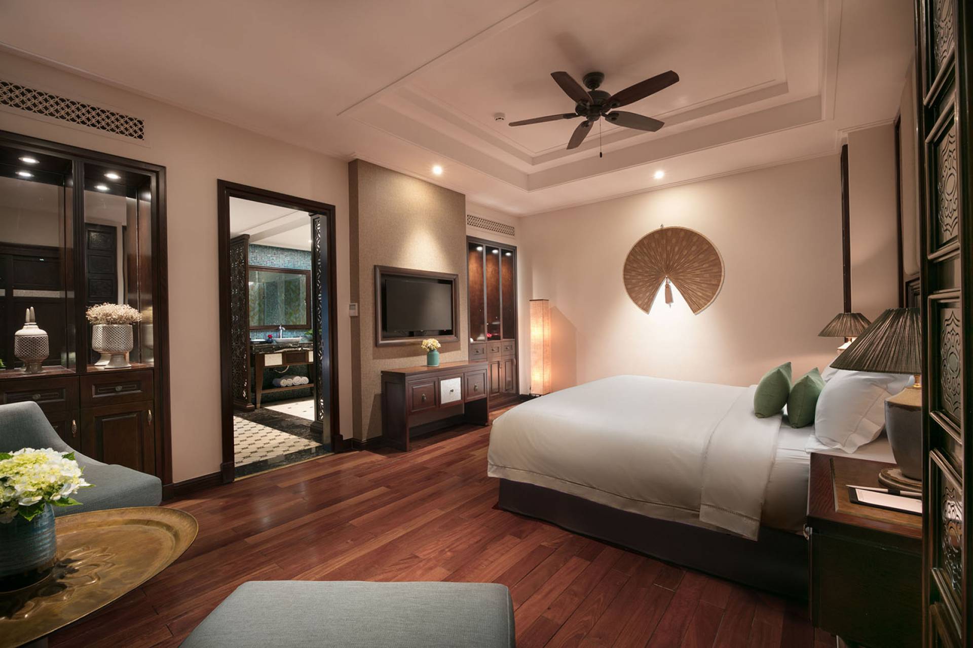 Spacious bedroom at Ninh Binh Hidden Charm Hotel & Resort featuring warm wooden floors and elegant Vietnamese-inspired interior design.