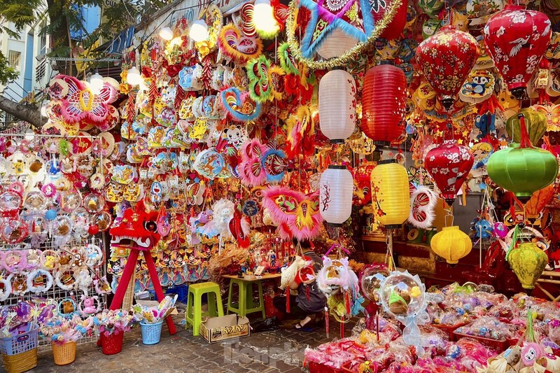 A brightly colored street stall packed with traditional toys, lanterns, and lion dance masks for the Mid-Autumn Festival in Vietnam in October