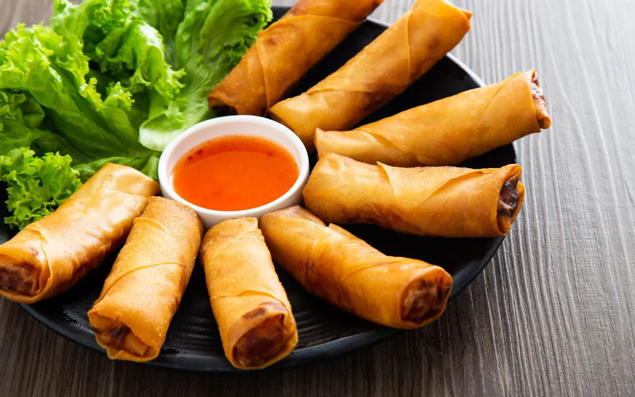 Crispy Vietnamese fried spring rolls served with sweet chili sauce and lettuce, a golden favorite among classic Vietnam street food dishes.