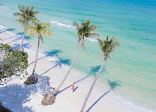 An aerial view of a pristine beach in Phu Quoc with white sand, ideal for a sunny getaway in Vietnam