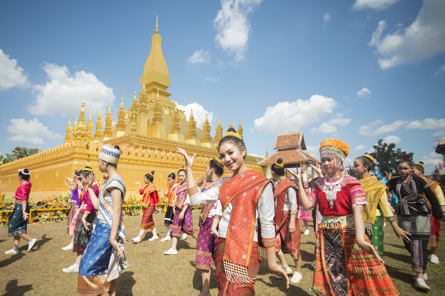 A group of young people in traditional attire performing a dance in Laos, a beautiful cultural display during the Best Time to Visit Southeast Asia