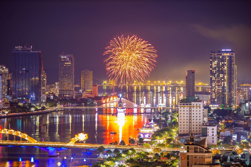 Brilliant fireworks reflecting on the Han River, highlighting that February is the best time to visit Da Nang for festivals