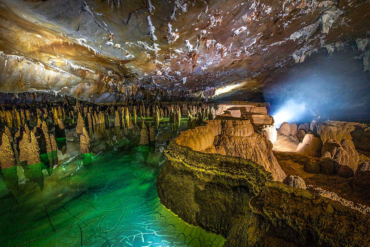 Inside Hang Va Caves, the bright green, highlighting a Vietnam adventure experience