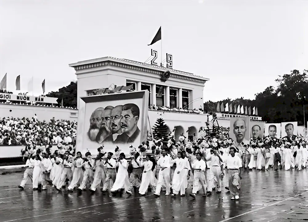 A historical black and white photo of a large parade on Ba Dinh Square