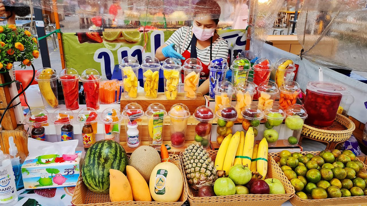 Vendor stall selling fresh fruit shakes and whole fruit, commonly seen at a Bangkok night market