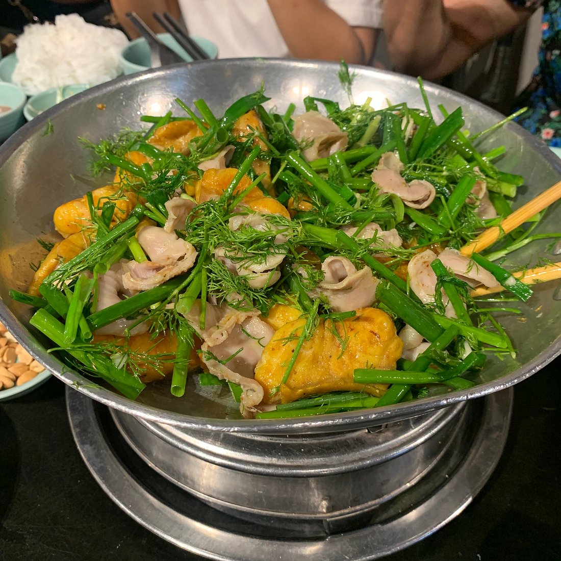 A hot metal bowl of Chả Cá Thăng Long, a Hanoi specialty, often enjoyed in the Hanoi Old Quarter