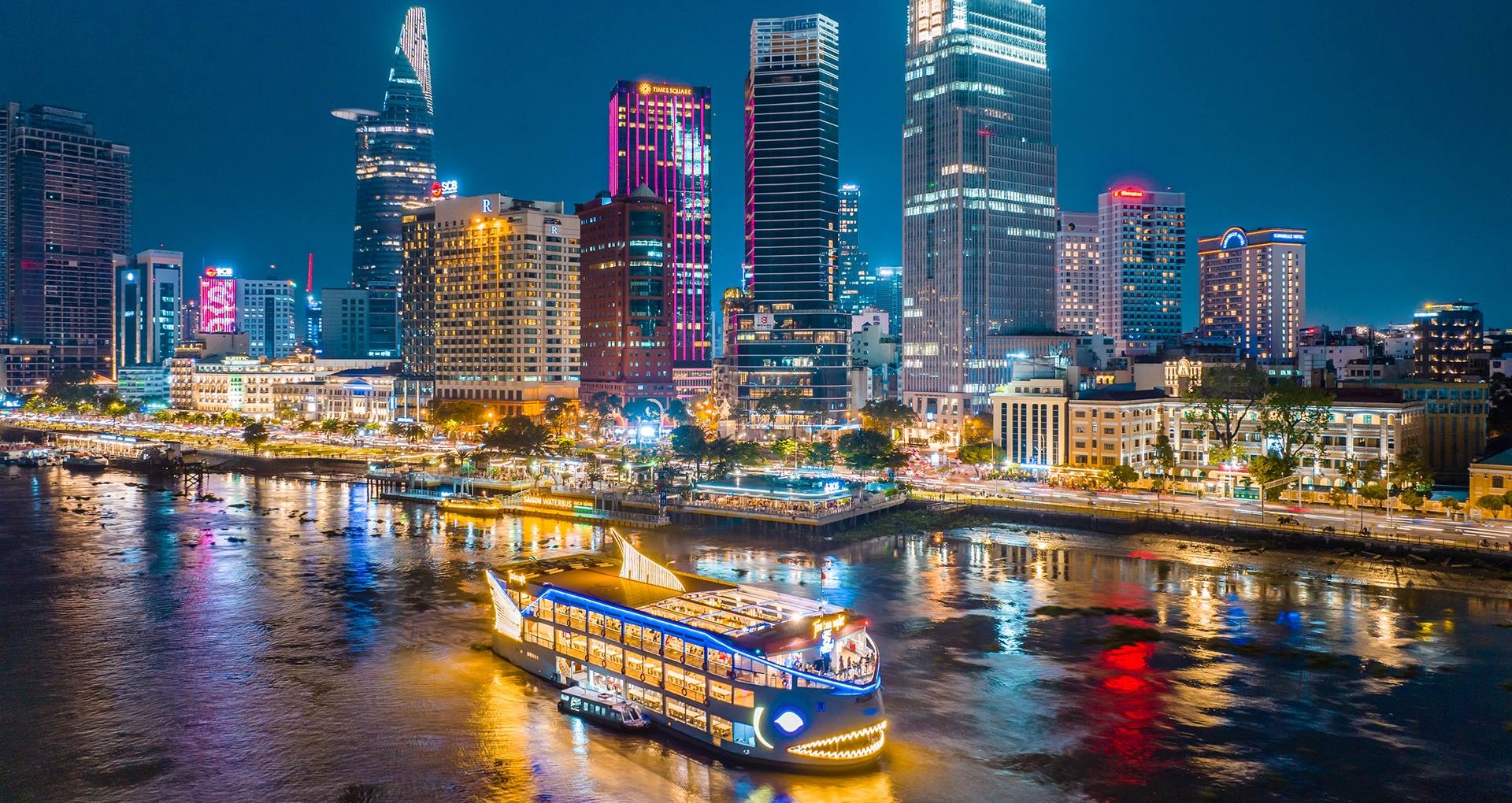 An illuminated cruise ship sailing on the Saigon River, showcasing the city's nightlife which makes any season a good time to visit ho chi minh city