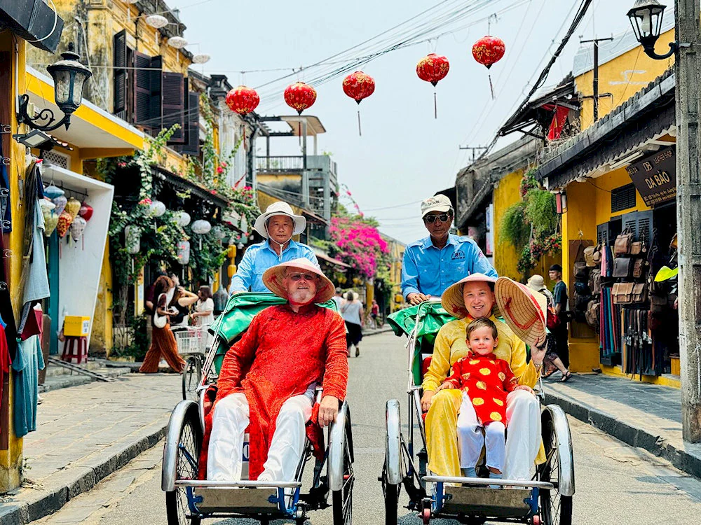Enjoying a cyclo ride through the lantern-adorned yellow streets of Hoi An's Ancient Town, a perfect experience for a hoi an private tour