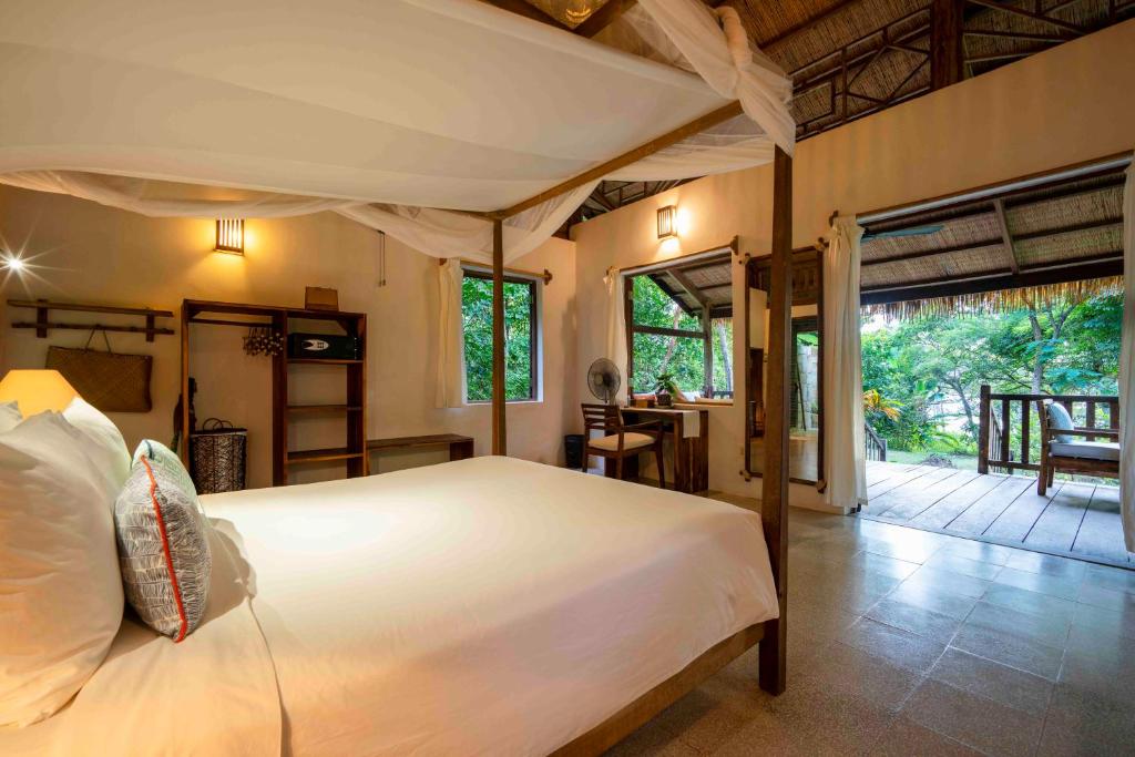 The bright, rustic interior of a charming bungalow bedroom at Mango Bay Resort, a feature of many phu quoc island holiday packages