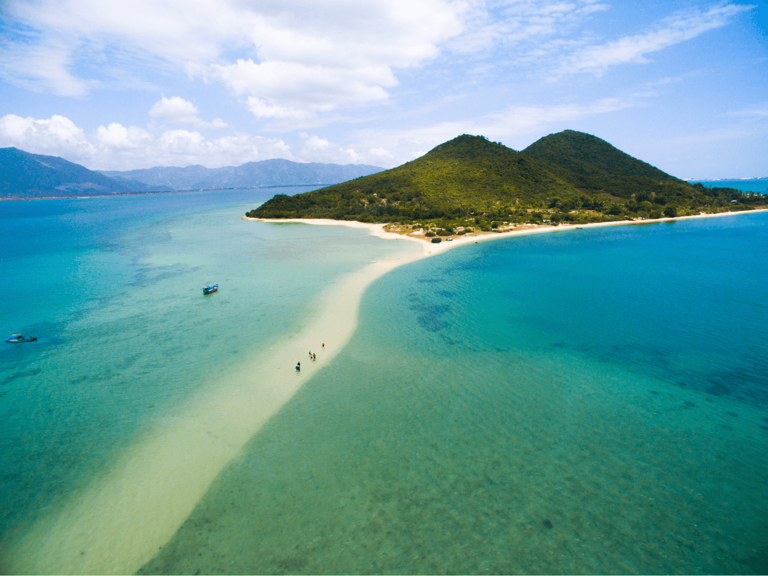 An elevated view of the turquoise bay and coastline of Nha Trang Vietnam, showcasing one of the best beaches in nha trang vietnam on a sunny day
