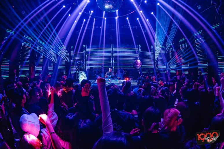 Street 1900 Club: Inside view of a busy Hanoi nightclub with a DJ, light shows, and a large crowd dancing, highlighting the vibrant nightlife venue