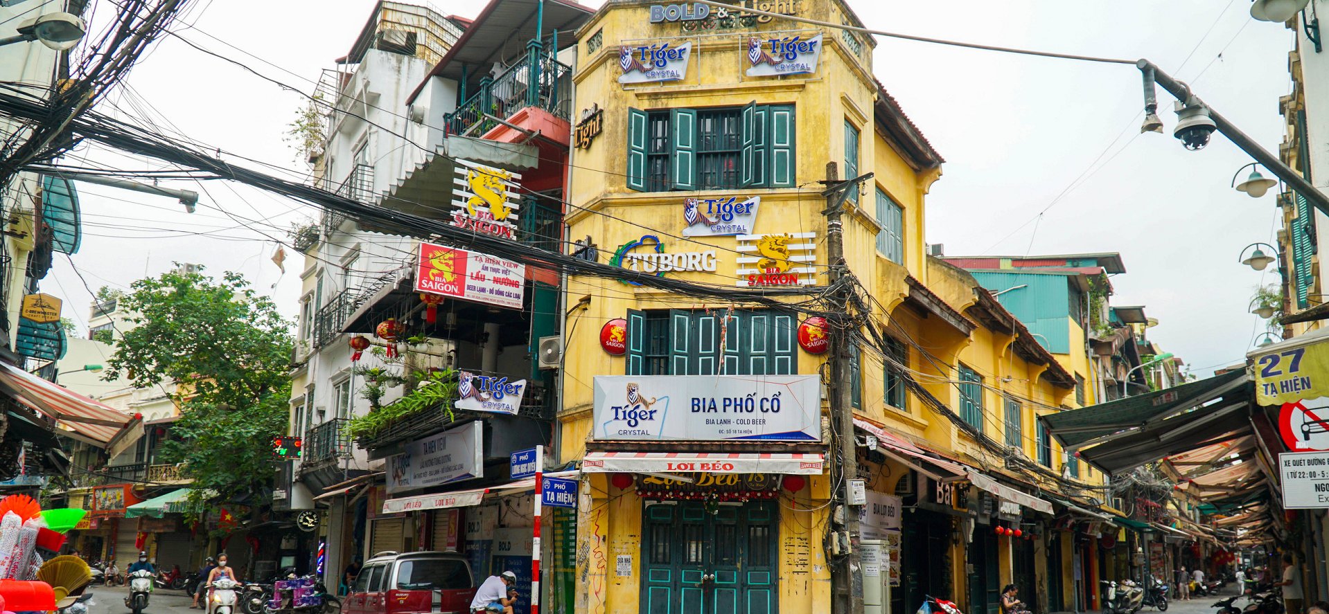 The Origin of the Name 'Beer Street Hanoi': Corner building in Hanoi Old Quarter with a 'BIA PHỐ CỔ' (Old Quarter Beer) sign, illustrating the iconic location."