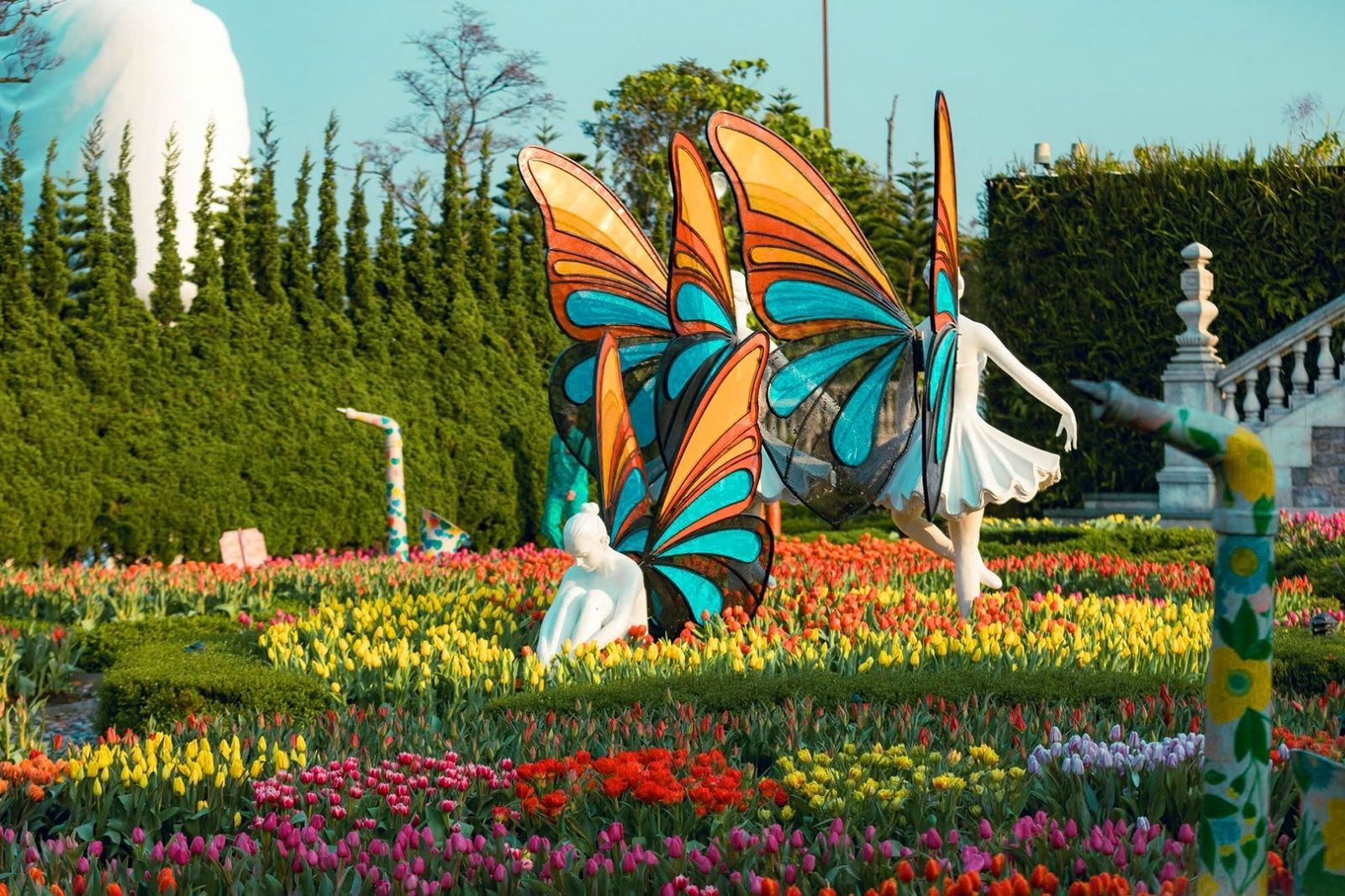 Colorful Jardin d’Amour near Golden Bridge Hoi An featuring butterfly statues and vibrant seasonal tulip displays.