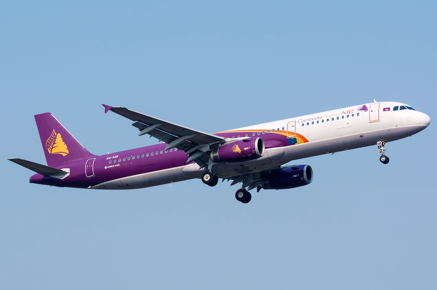 Travelling from Vietnam to Cambodia by Air: Cambodia Angkor Air Airbus A320 with purple livery taking off against a clear blue sky.