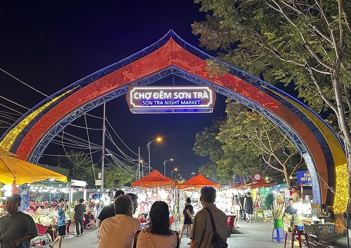 Colorful stalls at Son Tra Night Market Danang with tourists shopping at night.
