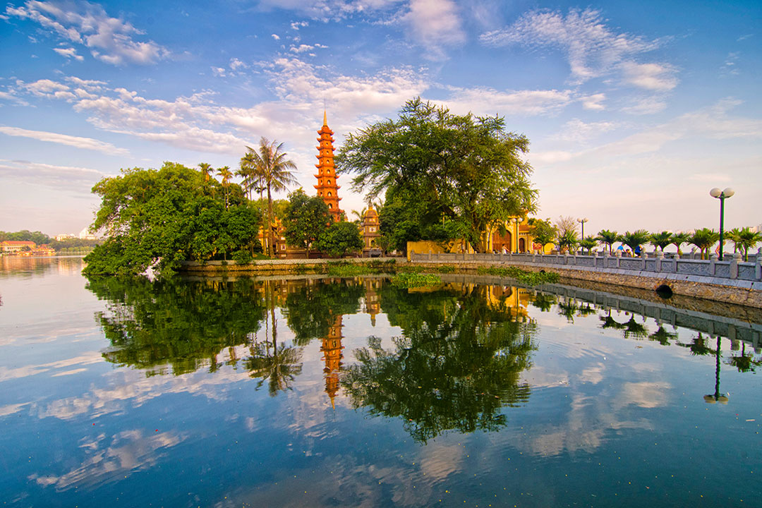 An aerial view of the red-tiled Tran Quoc Pagoda on an islet in West Lake, a featured stop on hanoi day tours