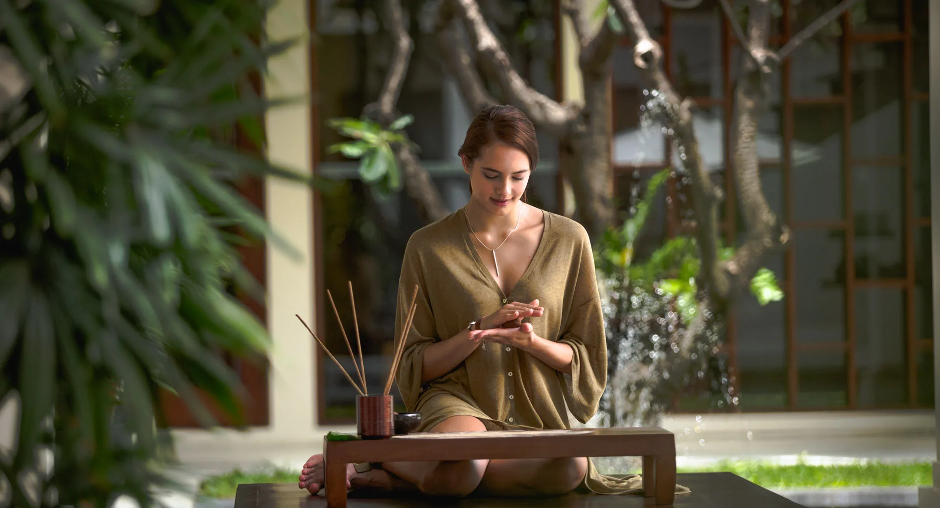 Luxury Vietnam & Cambodia Tour: Wellness & Relaxation: Woman meditating outdoors in a peaceful tropical setting, emphasizing health and tranquil moments on the trip.