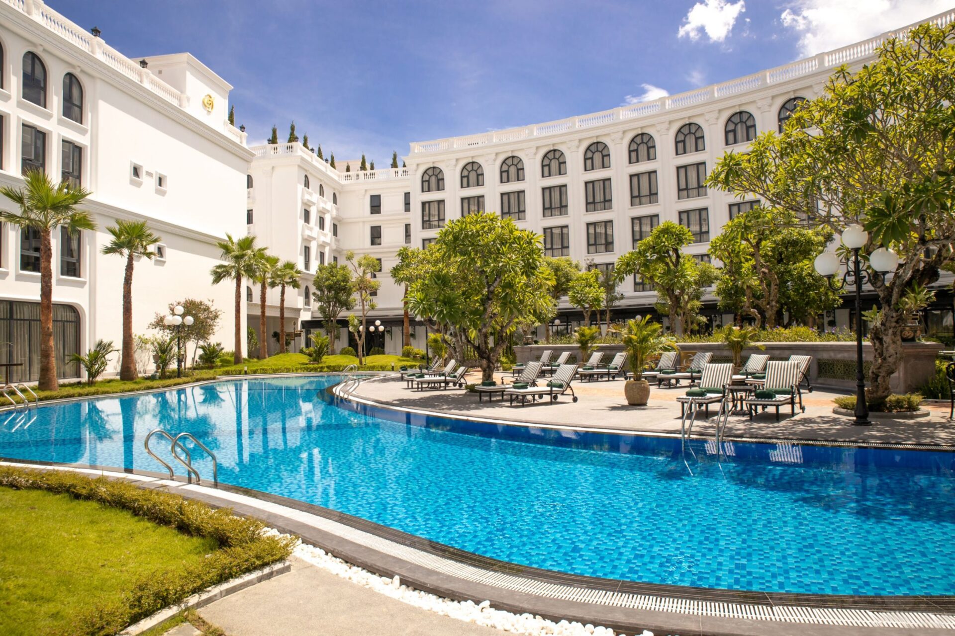 Outdoor swimming pool and garden view at silk path grand hue hotel in sunny Hue Vietnam.