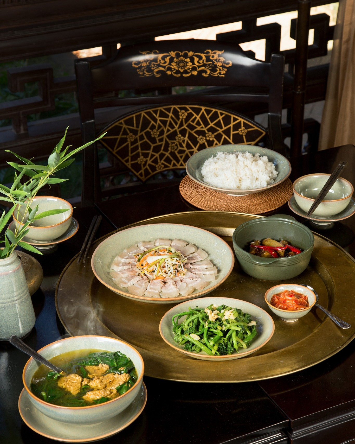 Traditional Vietnamese meal served at Ancient Hue Garden Houses with rice, vegetables, soup, and delicately arranged side dishes.
