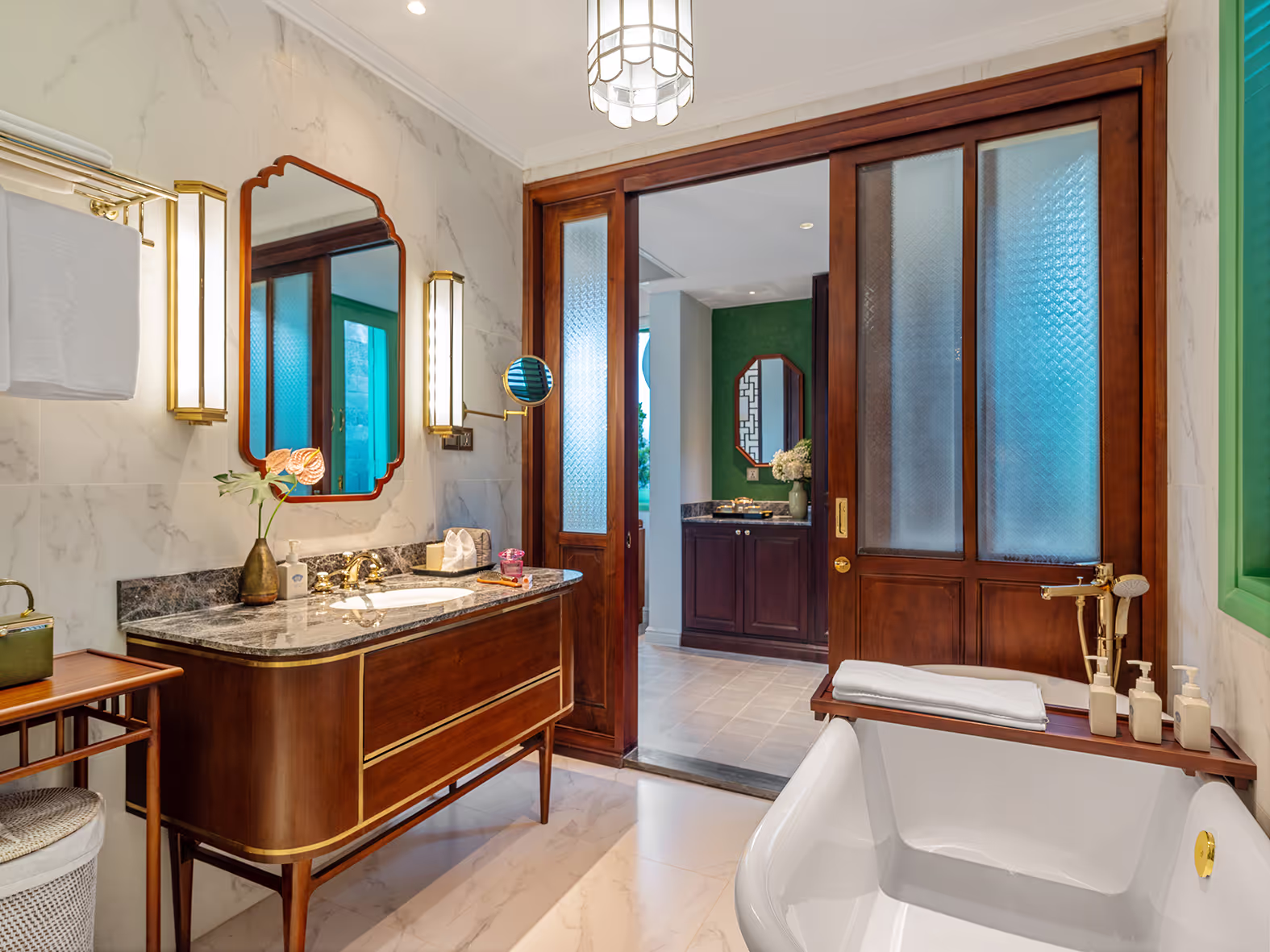 Luxury bathroom at Ancient Hue Garden Houses with marble walls, gold fixtures, wooden accents, and modern amenities blending classic Vietnamese design.