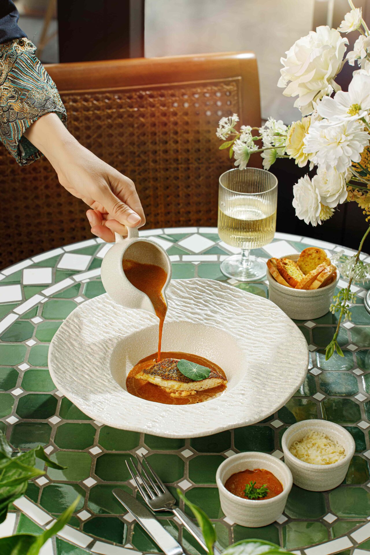 Fine dining at Ancient Hue Garden Houses with elegant plating, flavorful sauce, and contemporary Vietnamese fusion cuisine in natural light.