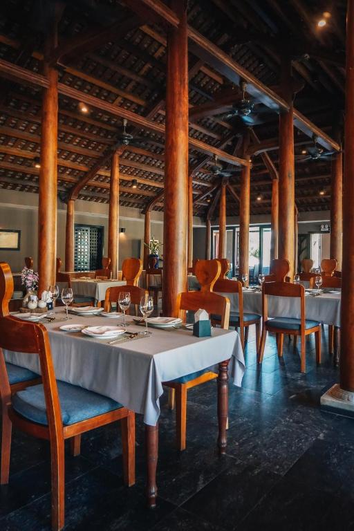 Elegant restaurant interior at Vedana Lagoon Resort Vietnam featuring wooden columns, soft lighting, and warm Vietnamese architecture.