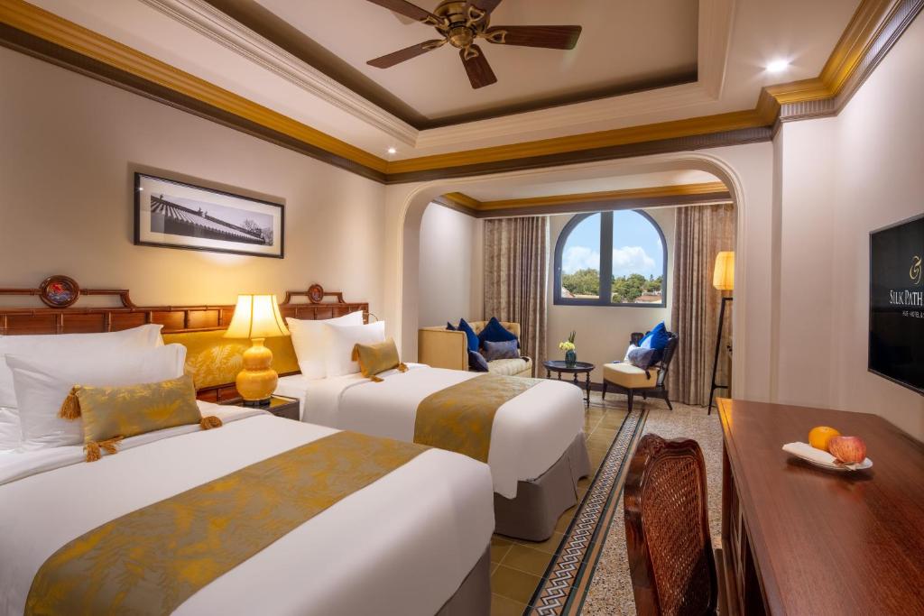 Deluxe twin room at silk path grand hue hotel decorated in warm tones and elegant style.
