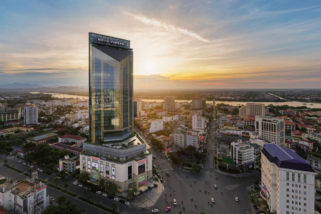 A stunning sunset view of Melia Vinpearl Hue, the tallest five-star hotel in Hue City, overlooking the Perfume River skyline.